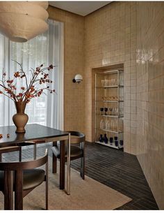 a vase with flowers is sitting on a table in the middle of a dining room