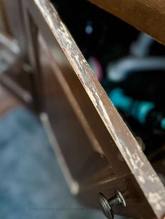 a close up view of a piece of metal on top of a wooden table with wheels