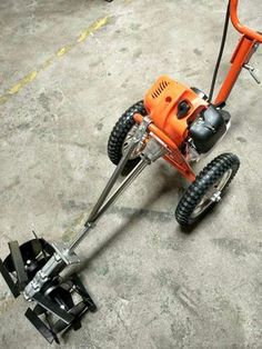 an orange lawn mower sitting on top of cement