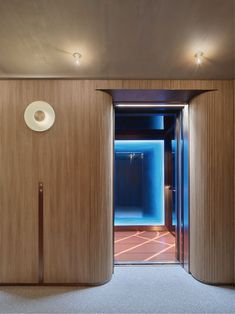 an open door leading into a room with wood paneling and blue lighting on the walls