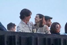 two women and one man are sitting at a table with drinks in front of them