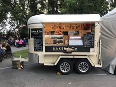 the food truck is parked on the side of the road in front of some people