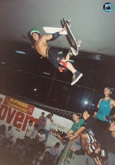 a man flying through the air while riding a skateboard in front of a crowd