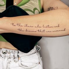 a woman with a tattoo on her arm that reads, to the stars we listen and the moon that stands