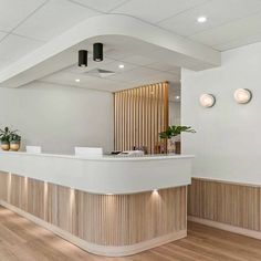 an empty reception area with white walls and wood accents