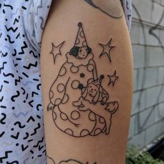 a person with a tattoo on their arm that has a dog in a birthday hat