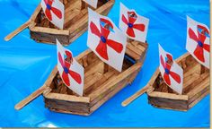 four wooden boats with red and white flags on them