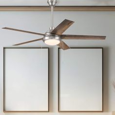 a ceiling fan in a living room with two pictures on the wall and one light