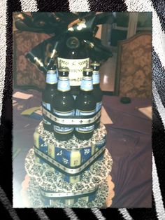 there is a cake made to look like a tower with beer bottles on the top