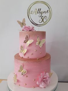 a pink and gold cake with butterflies on it