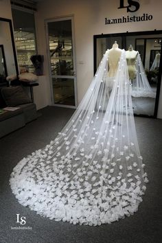 a wedding veil with white flowers on it