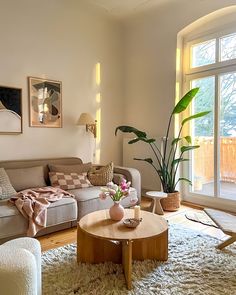 a living room filled with lots of furniture and a large window in the corner behind it