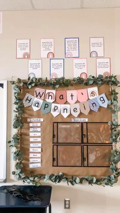 a bulletin board that has been decorated with green leaves and paper garlands on it