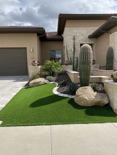 a house with a cactus in the front yard and green grass on the lawn area