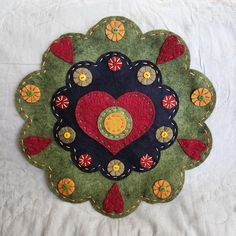 a patchwork heart is displayed on a white sheet