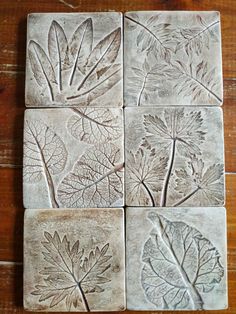 four square tiles with leaf designs on them