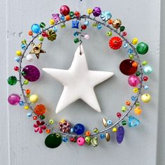 a white star hanging from the side of a door with beads and charms around it