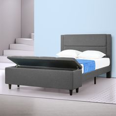 a bed that is sitting in the middle of a room with blue walls and stairs