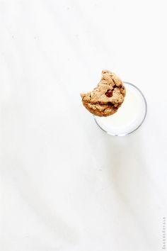 a glass filled with milk and two cookies