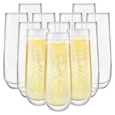 six champagne glasses filled with liquid on a white background