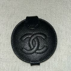 a black chanel coin case sitting on top of a table