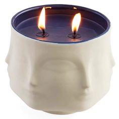 two candles are lit in the shape of a human's head on a white background