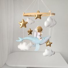 a baby crib mobile with a dolphin and stars hanging from it