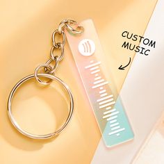 a keychain with a music note on it sitting next to a pair of scissors