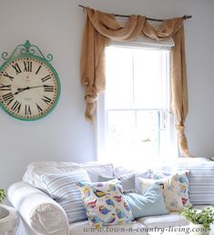 a living room filled with furniture and a large clock mounted to the wall above it