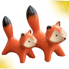 two ceramic fox figurines sitting next to each other