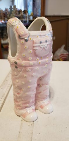 a ceramic baby's bib and boot sitting on top of a table