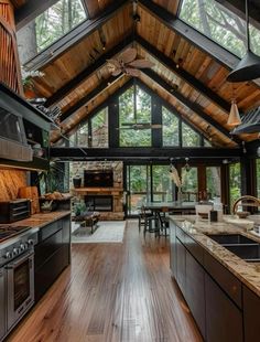 an open kitchen and dining area with wood flooring in a cabin style home on the edge of a forest