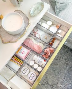 the drawers are organized with various items such as candles, soaps and other things