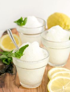 three small glass bowls filled with lemon and mint ice cream on top of a wooden cutting board