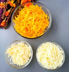 three bowls filled with different types of cheeses on top of a gray countertop