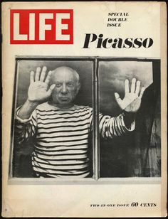 an old man standing in front of a window holding his hands up to the side