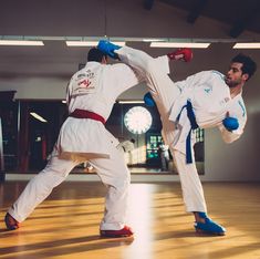 two men in white and blue uniforms doing karate