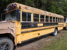 an old yellow school bus parked in a field