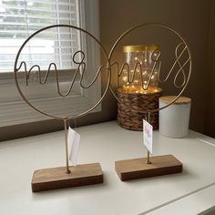 two metal wire sculptures on top of a white counter next to a basket with candles