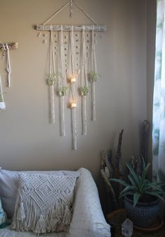 a white couch sitting under a window next to a wall hanging with lights on it