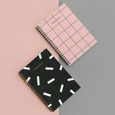 two notebooks on top of each other next to one another with black and white designs