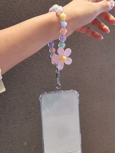 a woman's hand holding a cell phone charm