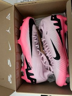 two pairs of pink and black nike shoes in a box