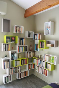 a room filled with lots of books on top of shelves next to a wall mounted tv