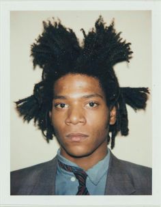 a young man with dreadlocks on his head wearing a suit jacket and tie