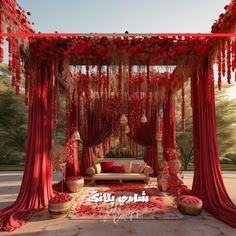 an outdoor wedding setup with red draping and flowers on the bed, couches and tables