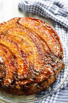 an upside down pineapple cake on a plate with blue and white checkered cloth