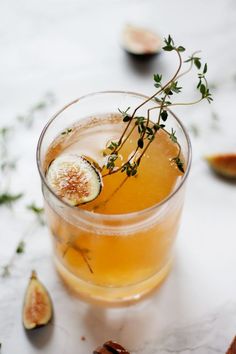 a glass filled with an alcoholic drink and garnished with figs on the side