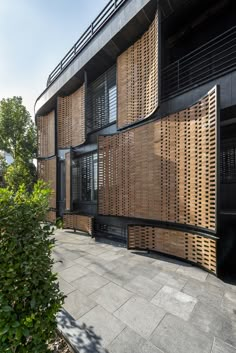 an apartment building with wooden shutters on the front and side walls, surrounded by greenery