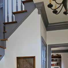 an open door leading to a living room and dining area with stairs in the background